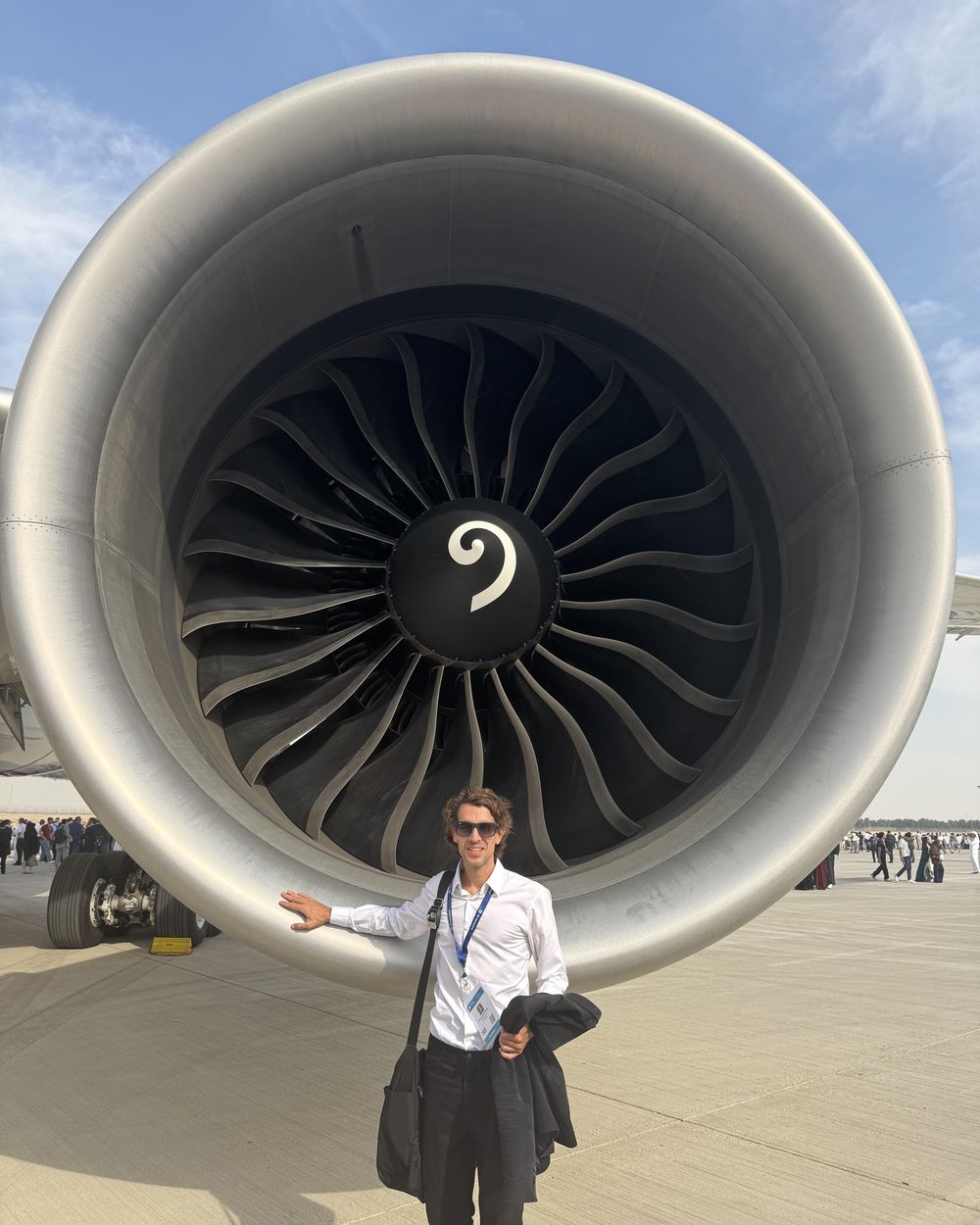 Chris Noon standing beside the air intake of a large commercial jet engine